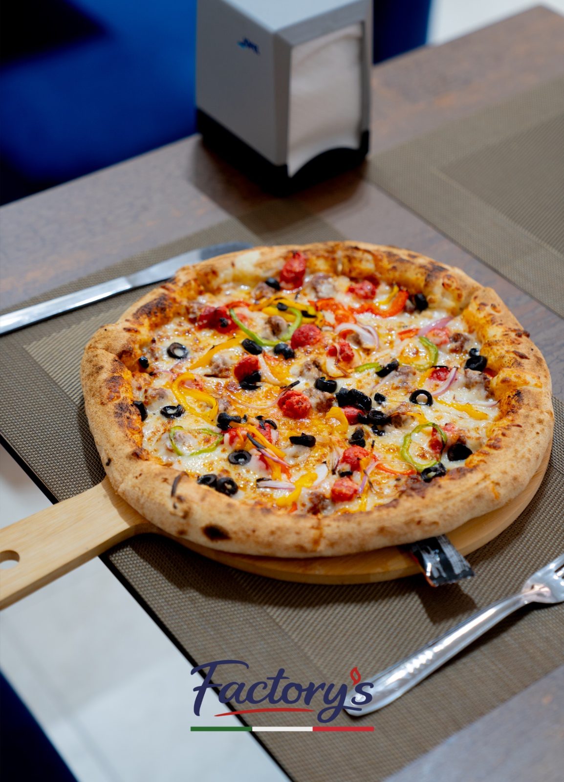 Pizza artisanale Factory's présentée sur une pelle en bois